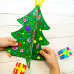 Two hands holding a Christmas tree craft project for kids. 